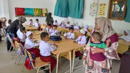 Bahkan, beberapa orangtua siswa sampai masuk ke ruang kelas untuk mendampingi anaknya. (Chaideer MAHYUDDIN/AFP)