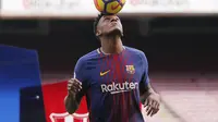 Bek anyar Barcelona, Yerry Mina mengontrol bola dengan kepalanya saat perkenalan dengan para fans Blaugrana di Stadion Camp Nou, Barcelona, Spanyol, Sabtu (13/1). Mina menerima kontrak berdurasi lima tahun hingga 2023. (Pau Barrena / AFP)