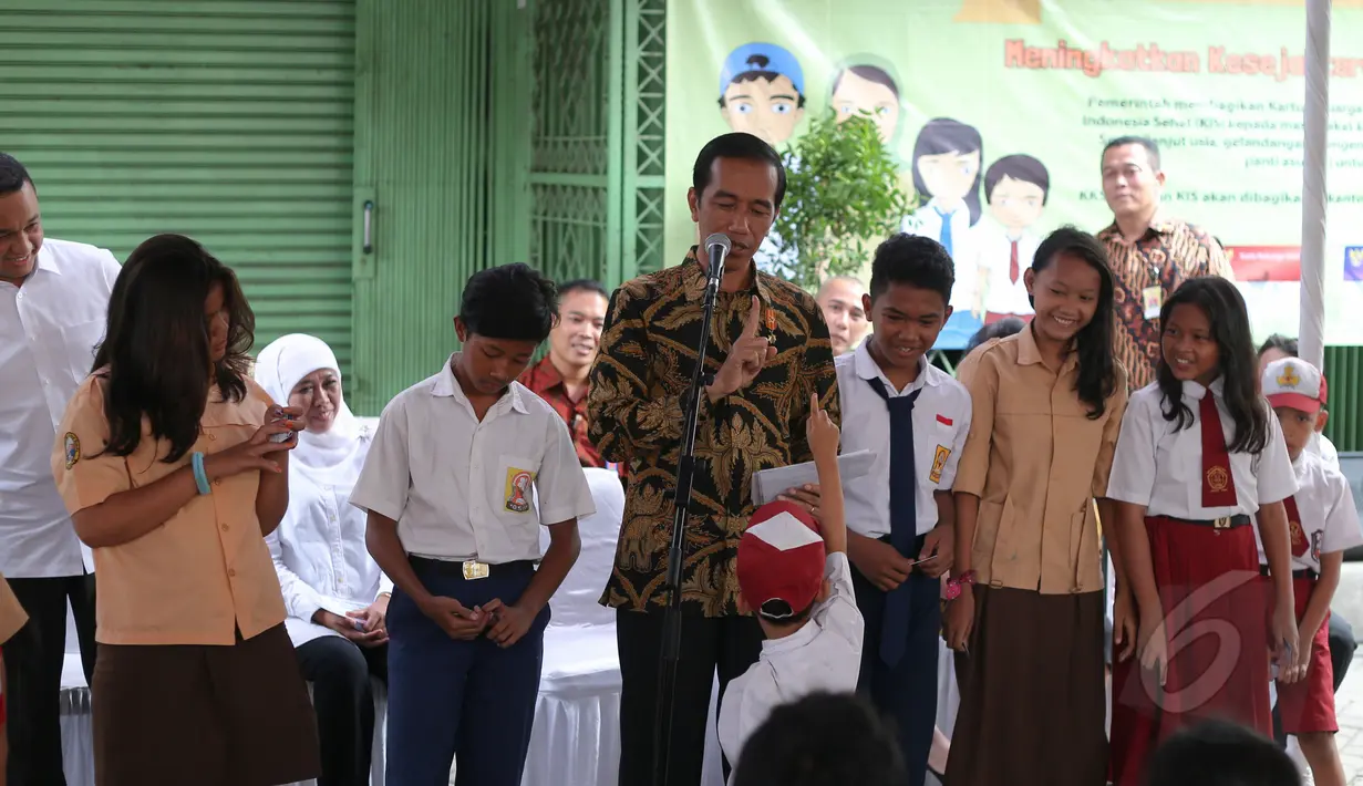 Presiden Jokowi berdialog dengan pelajar saat pembagian Kartu Indonesia Sehat (KIS), Kartu Indonesia Pintar dan Kartu Keluarga Sejahtera (KKS) kepada masyarakat di Penjaringan, Jakarta, Rabu (13/5). (Liputan6.com/Faizal Fanani)