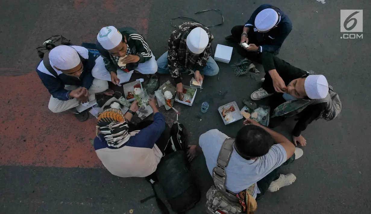 Massa Gerakan Nasional Kedaulatan Rakyat berbuka puasa bersama saat unjuk rasa di kawasan Bundaran HI, Jakarta, Selasa (21/5/2019). Dalam aksinya, mereka Bawaslu memeriksa hasil Pemilu 2019 yang dinilai banyak terdaopat kecurangan. (Liputan6.com/Herman Zakharia)