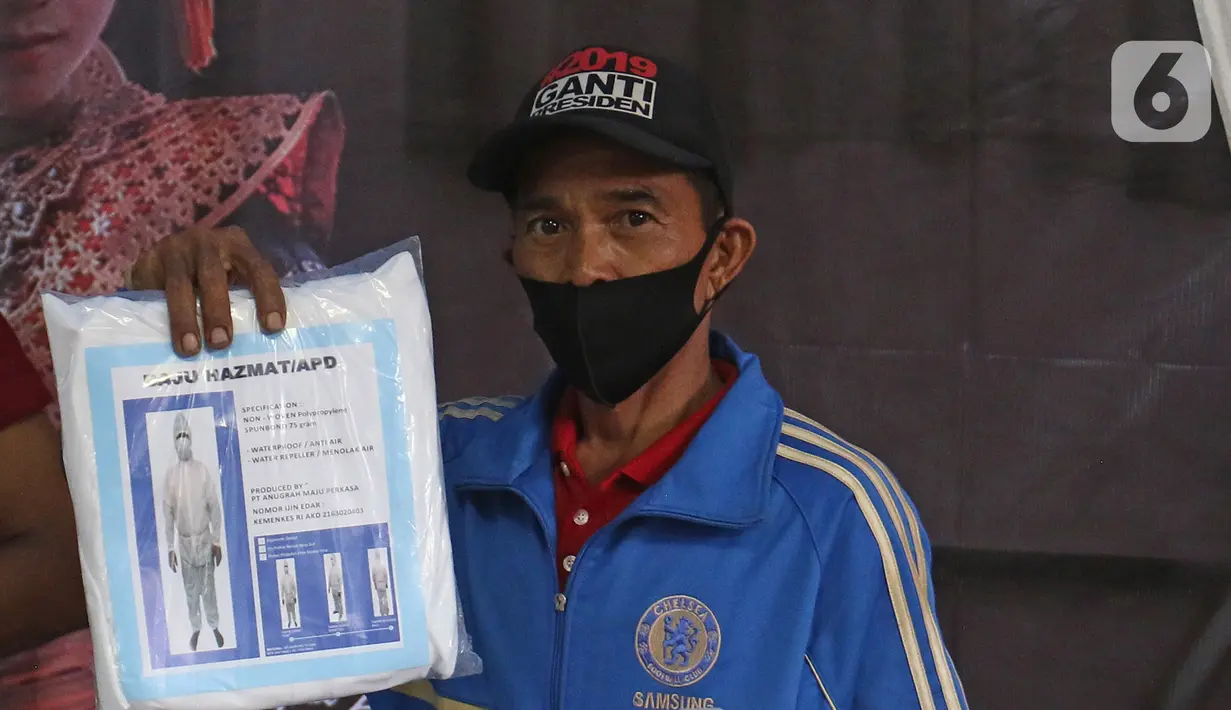 Petugas menunjukkan hazmat di Tempat Pemungutan Suara (TPS) 33 di lingkungan RT 05 RW 06 Kelurahan Cipayung, Depok, Jawa Barat, Selasa (8/12/2020). Sejumlah logistik pilkada Depok 2020 di distribusikan dari kelurahan Cipayung ke sejumlah TPS. (Liputan6.com/Herman Zakharia)