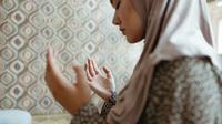 Wanita berdoa menengadahkan kedua tangan (Pexels)