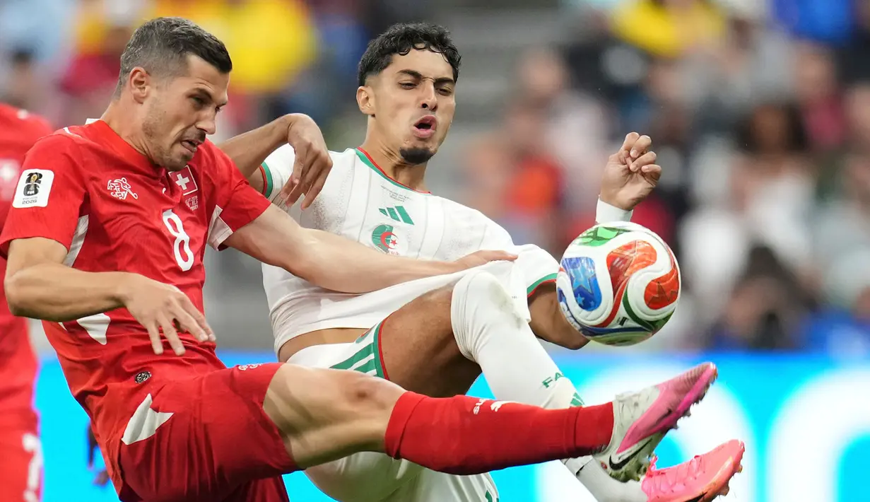 Pemain Swiss Remo Freuler berebut bola dengan pemain Aljazair Fares Chaibi selama pertandingan sepak bola babak 32 Piala Dunia antara Swiss dan Aljazair di Vancouver, British Columbia, (AP Photo/Abbie Parr)
