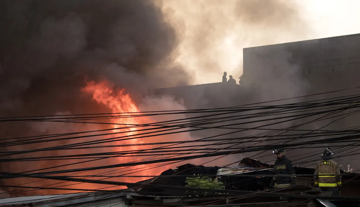 Petugas pemadam kebakaran berusaha memadamkan api yang melanda daerah kumuh di Manila, Filipina (23/5). Menurut laporan media setempat, kebakaran tersebut menghancurkan 200 rumah yang mempengaruhi 300 keluarga. (AFP Photo/Noel Celis)