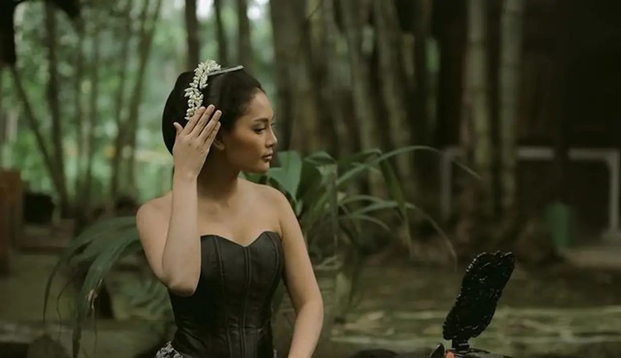 Berperan sebagai bu Djujuk di film Srimulat, Erika Carlina tampil ayu mengenakan bustier hitam yang dipadukan dengan kain. Rambutnya pun disanggul lengkap dengan untaian bunga melati. (instagram/eri.carl)