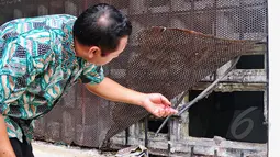 Petugas BNN mengecek kondisi tembok ruang tahanan yang dijebol para tahanan untuk melarikan diri, Jakarta, Selasa (31/3/2015). Tembok ruang tahanan BNN berukuran 16 milimeter, luas jebolan 30 sentimeter (cm) dengan lebar 40 cm. (Liputan6.com/Yoppy Renato)