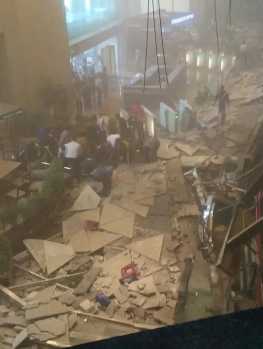 Sejumlah orang mengevakuasi korban dari robohnya balkon lantai 1 tower II Bursa Efek Indonesia (BEI) roboh, Jakarta, Senin (15/1). Pegawai dan pengunjung yang diduga tertimpa puing langsung dievakuasi ke luar BEI. (Liputan6.com/istimewa)