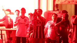 Anggota IndoManutd menyalakan suar saat Rasmus Hojlund mencetak gol pertama timnya saat acara Roaring Night antara Manchester United melawan  West Ham di Pitch 98, Kemang, Jakarta, Minggu (04/02/2024) malam WIB. (Bola.com/Abdul Aziz)