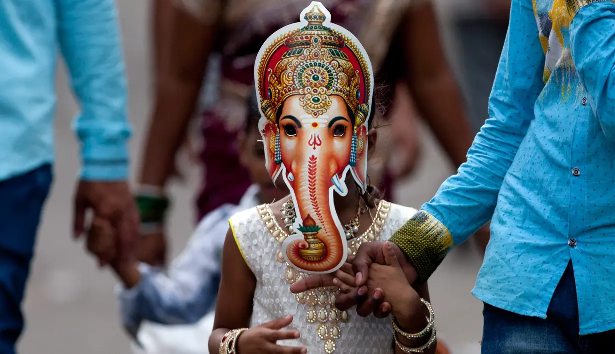 Gadis India mengenakan topeng Dewa Ganesha dalam rangka festival Ganesha Chaturthi di Hyderabad, India, Selasa (5/9). Dalam festival ini, seluruh umat hindu India memperingati hari lahir Dewa Ganesha. (Mahesh Kumar A/AP Photo)