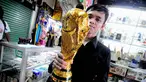 Seorang pedagang menunjukkan replika Piala Dunia di sebuah toko kawasan Pasar Senen, Jakarta, Selasa (24/6/14). (Liputan6.com/Faizal Fanani)