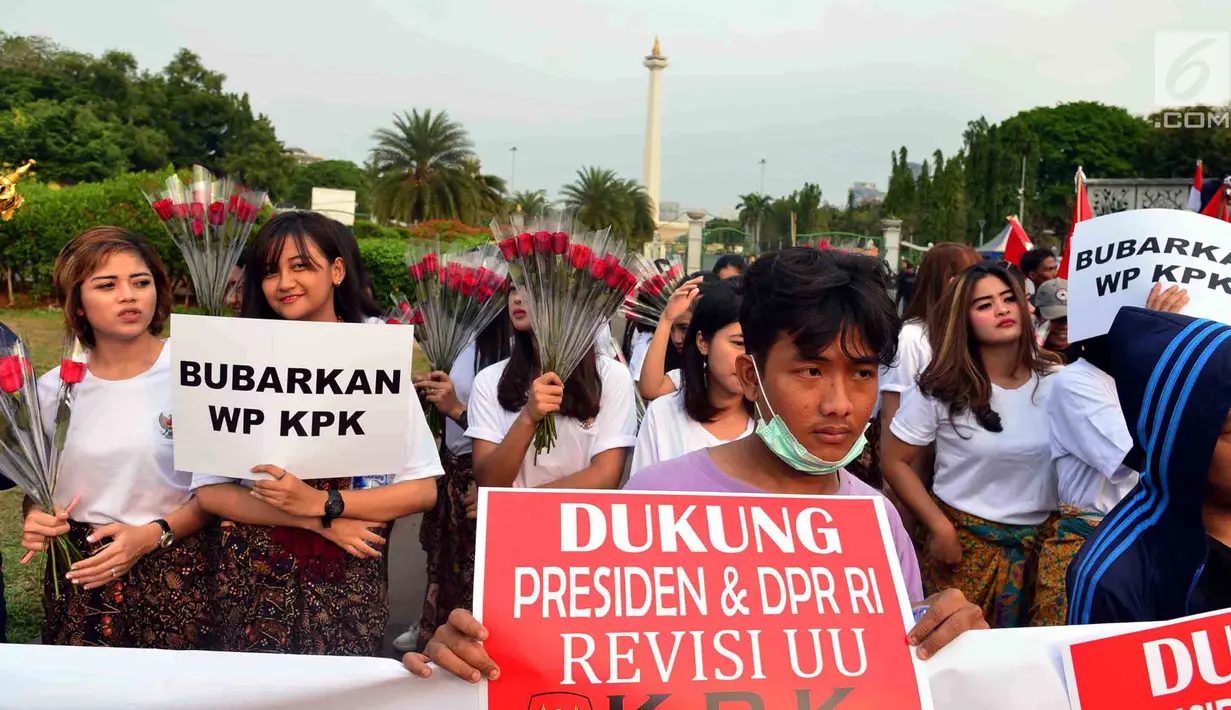 Massa membentangkan spanduk dalam aksi meminta revisi UU KPK di depan Istana, Jakarta, Jumat (13/9/2019). Dalam aksinya, mereka juga mendukung keberadaan Dewan Pengawas KPK agar KPK tetap independen dan bebas dari intervensi politik. (Liputan6.com/Johan Tallo)