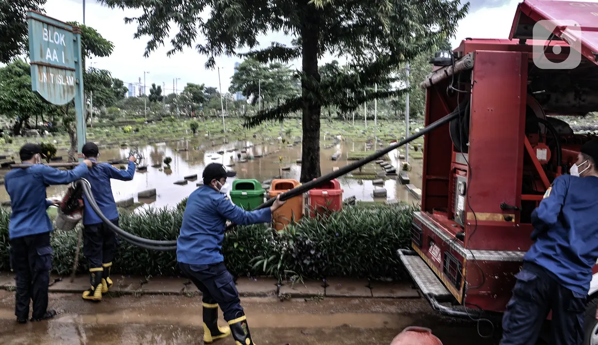 Petugas Pemadam Kebakaran mengerahkan alat penyedot air saat banjir merendam TPU Karet Bivak, Jakarta, Minggu (7/2/2021). Banjir terjadi akibat lahan tak lagi mampu menampung air hujan serta diperparah dengan lokasi 3 blok makam yang berada di cekungan. (merdeka.com/Iqbal Nugroho)