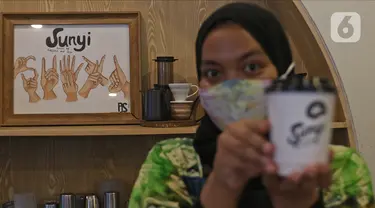 Barista menunjukkan kopi buatannya di Sunyi House of Coffee and Hope, Jakarta, Jumat (15/1/2021). Rumah kopi ini mempekerjakan difabel untuk melayani pengunjung dan mengajari bahasa isyarat alfabet. (Liputan6.com/Herman Zakharia)