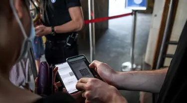 Penonton diperiksa paspor kesehatannya sebelum memasuki bioskop Grand Rex di Paris, Rabu (21/7/2021). Orang-orang yang pergi ke bioskop, museum atau pertandingan olahraga di Prancis harus membuktikan mereka telah divaksin atau hasil tes negatif Covid-19 yang berlaku selama 48 jam. (ALAIN JOCARD/AFP)