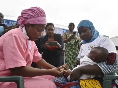 Petugas kesehatan memberikan vaksin malaria Oxford-Serum R21 kepada seorang anak di Abidjan, Pantai Gading, Senin (15/7/2024). (AP Photo/Diomande Ble Blonde)