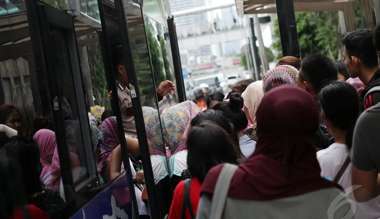 Warga terlihat berdesakan untuk menaiki bus tingkat wisata di Halte Bundaran HI, Jakarta, Kamis (1/1/2015). (Liputan6.com/Faizal Fanani)