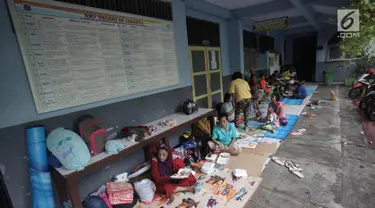 Warga yang rumahnya terendam banjir mengungsi di Gedung SMP Negeri 26, Jalan Kebon Pala, Kampung Melayu, Jatinegara, Jakarta Timur, Selasa (6/2). Sebanyak 42 KK mengungsi di tempat tersebut. (Liputan6.com/Arya Manggala)