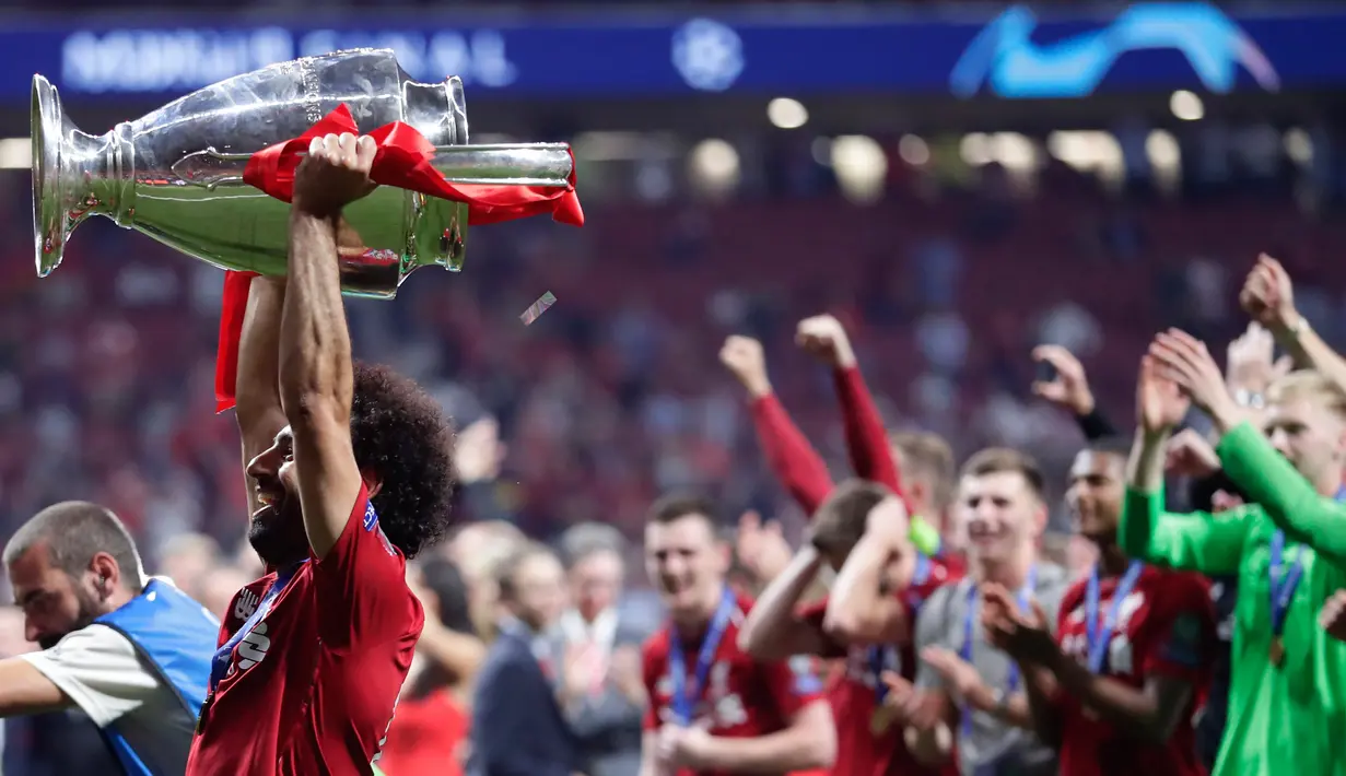 Pemain Liverpool Mohamed Salah mengangkat trofi juara Liga Champions usai mengalahkan Tottenham Hotspur di Stadion Wanda Metropolitano, Madrid, Spanyol, Sabtu (1/6/ 2019). (AP Photo/Manu Fernandez)