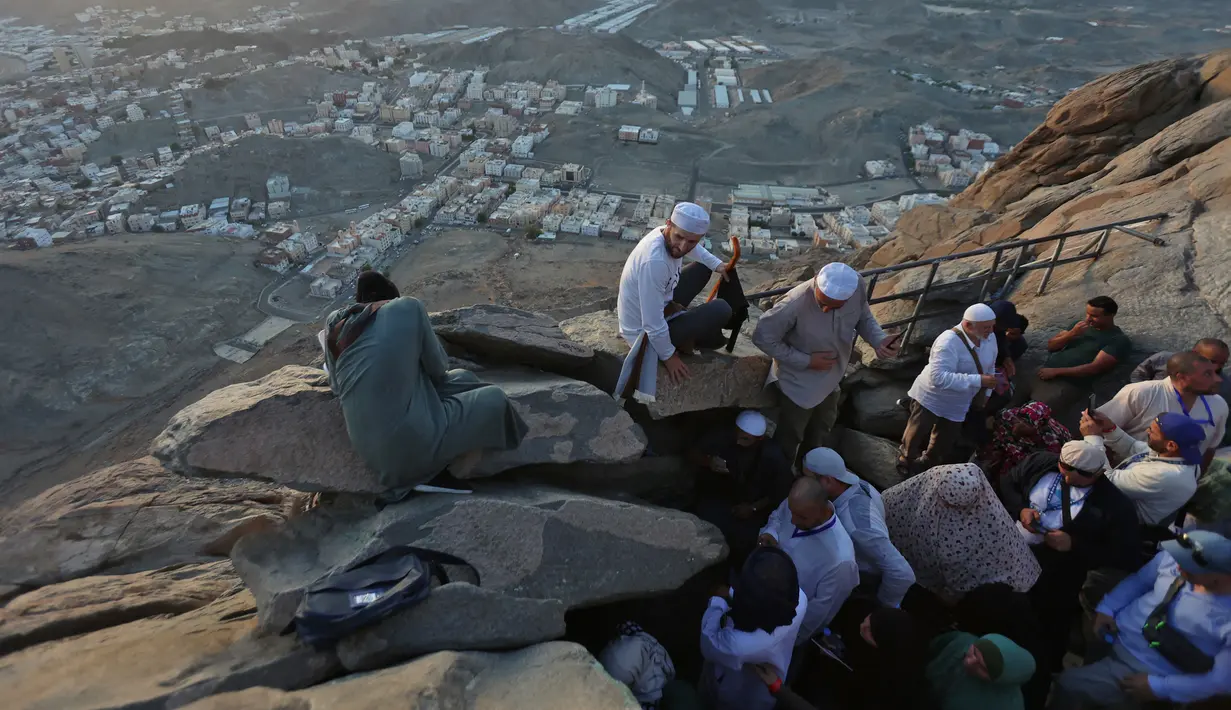 Peziarah muslim berfoto di Jabal al-Noor atau Gunung Cahaya yang menghadap ke Kota Suci Mekkah, Arab Saudi, 5 Juli 2022. Satu juta orang, termasuk 850 ribu dari luar negeri, diizinkan untuk berpartisipasi dalam haji tahun ini setelah dua tahun terakhir jumlahnya dikurangi secara drastis karena pandemi virus corona COVID-19. (Christina ASSI/AFP)
