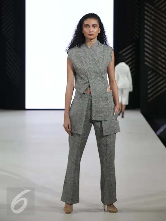 Seorang model berpose diatas panggung saat memperagakan busana rancangan MADE IND X TANGAN dalam pagelaran Senayan City Fashion Nation ke-11, Jakarta, Senin (10/4). (Liputan6.com/Faizal Fanani)