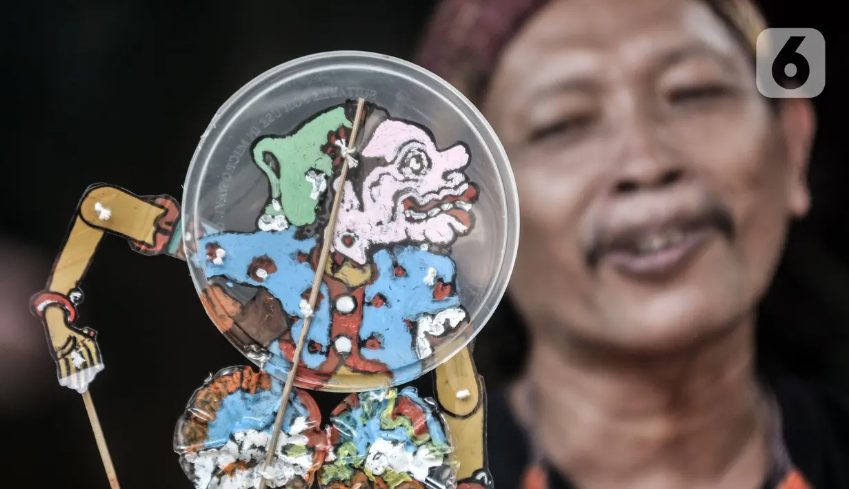 Seniman Iskandar Hardjodimuljo menjadi dalang memainkan wayang uwuh di kawasan Cawang, Jakarta, Kamis (29/10/2020). Pandemi COVID-19 menyebabkan penjualan sekaligus produksi wayang uwuh karya Iskandar merosot hingga 60 persen dibandingkan sebelumnya. (merdeka.com/Iqbal S. Nugroho)