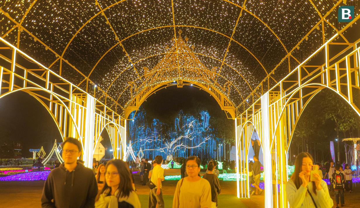 Para pengunjung sedang menikmati lorong dengan warna-warni lampu yang bertempat di Charming Chiang Mai Flower Festival pada Kamis (11/12/2025). (Bola.com/Bagaskara Lazuardi)