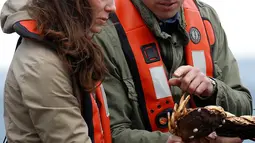 Kate Middleton dan Pangeran William melihat kepeting hasil tangkapannya saat memancing bersama di Haida Gwaii, Kanada, (30/9). (REUTERS/Chris Wattie)