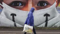 Seorang pria berjalan melewati sebuah lukisan dinding oleh seniman Cosimo Cheone yang didedikasikan untuk perawat rumah sakit Sacco, di Milan, Italia, pada 24 Juli 2020. (AP Photo / Luca Bruno)