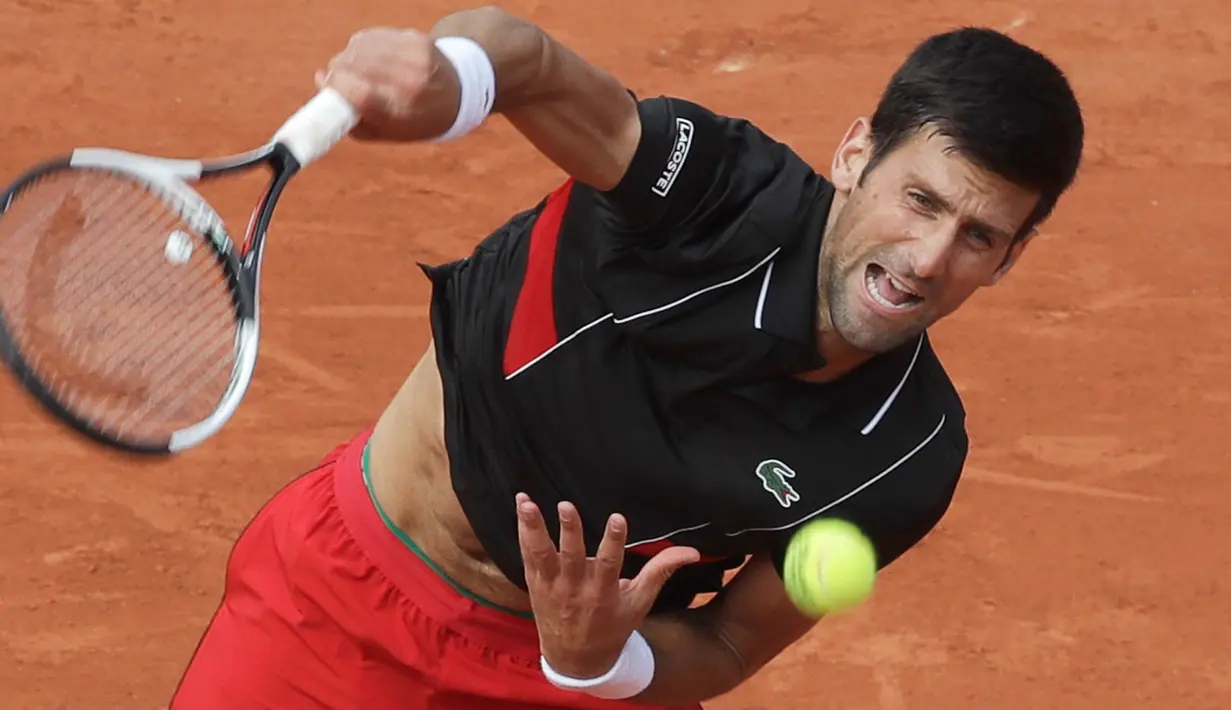 Petenis Serbia, Novak Djokovic mengembalikan bola ke petenis Italia Marco Cecchinato pada perempatfinal Prancis Terbuka 2018 di stadion Roland Garros, Selasa (5/6). Djokovic dikalahkan petenis non-unggulan dalam duel empat set. (AP/Alessandra Tarantino)