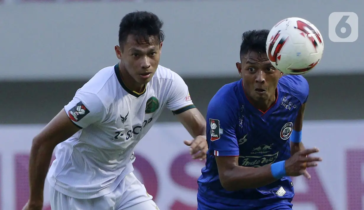 Bek Persikabo 1973 Andy Setyo Nugroho berebut bola dengan pemain Arema FC Dedik Setiawan pada laga Piala Menpora di Stadion Manahan, Solo, Minggu (21/3/2021). Kedua tim bermain imbang 1-1. (Bola.com/M Iqbal Ichsan)