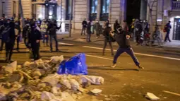 Demonstran bentrok dengan polisi saat memprotes penangkapan rapper Pablo Hasel di Barcelona, Spanyol, Selasa (16/2/2021). Aksi protes meletus di Spanyol setelah polisi menangkap Pablo Hasel yang menolak hukuman penjara karena menghina kerajaan dan memuji terorisme. (AP Photo/Emilio Morenatti)