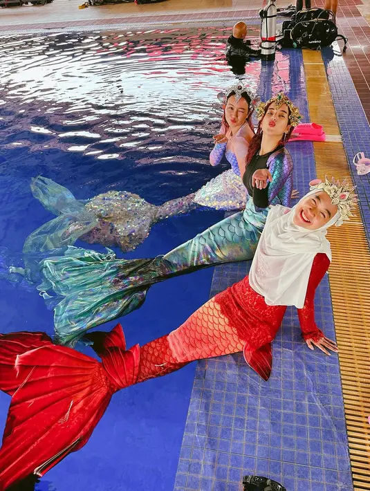 Lalu ada Nanda Arsyinta dengan kostum putri duyung nuansa ungu yang dihiasi sirip hologram berkilauan. Penampilan ketiganya makin totalitas dengan headpiece ala princess Ariel. Super gemas! [Instagram/tasyafarasya/nandarsynt]