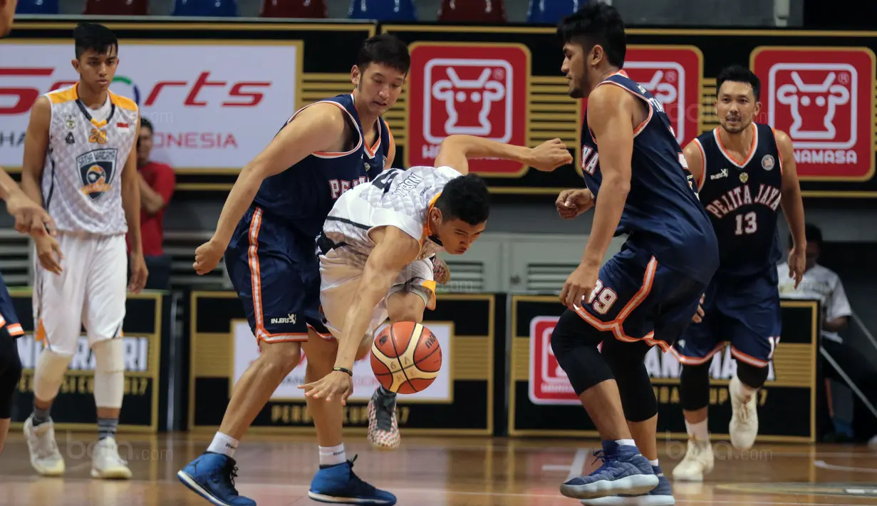 Pebasket Satya Wacana, Nuban David Liberty (tengah) melewati adangan pemain Pelita Jaya pada laga Perbasi Cup 2017 di Sports Mall, Kelapa Gading, Jakarta, (06/11/2017). Pelita Jaya menang 92-46. (Bola.com/Nick Hanoatubun)