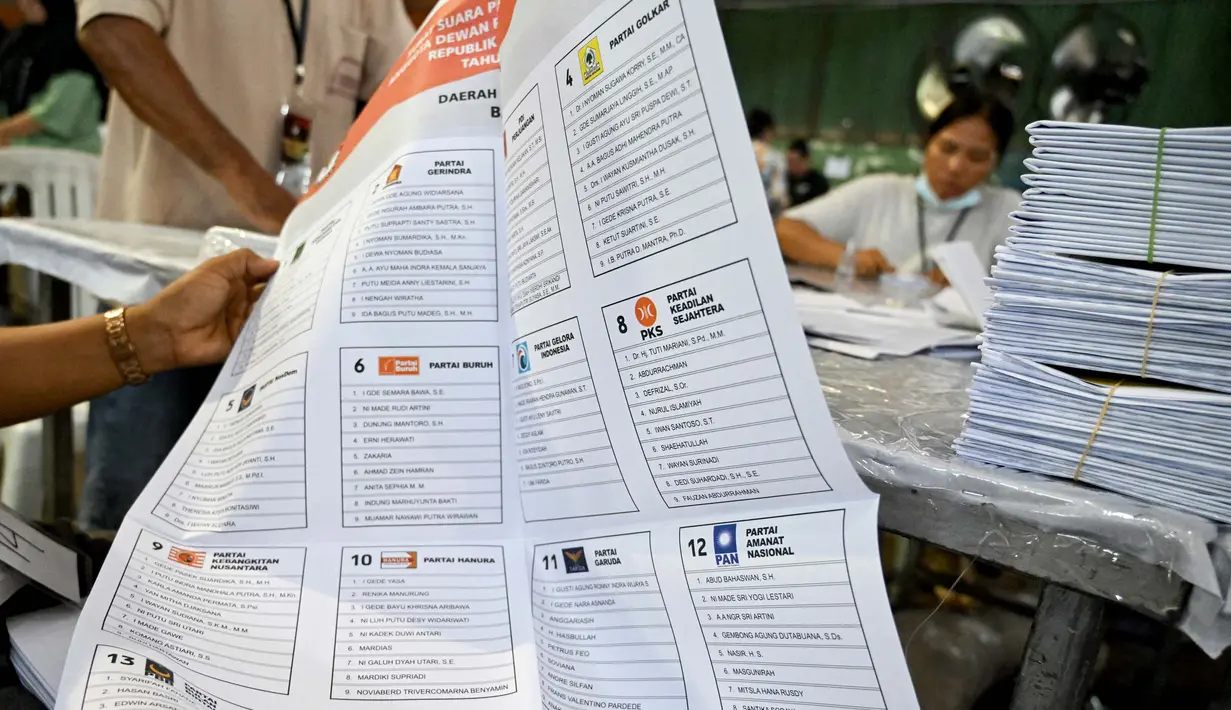 Para staf melipat surat suara pemilihan umum Indonesia 2024 di Gudang Logistik Komisi Pemilihan Umum (KPU) Denpasar, Bali, pada 14 Desember 2023. (SONNY TUMBELAKA/AFP)