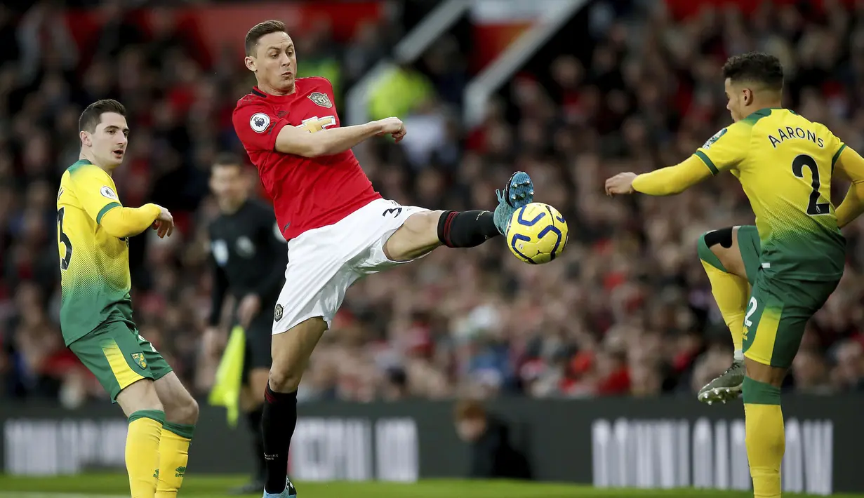 Gelandang Manchester United, Nemanja Matic berebut bola dengan bek Norwich City, Aarons pada pertandingan lanjutan Liga Inggris di Old Trafford (11/1/2020). MU menang telak 4-0 atas Norwich. (Martin Rickett/PA via AP)