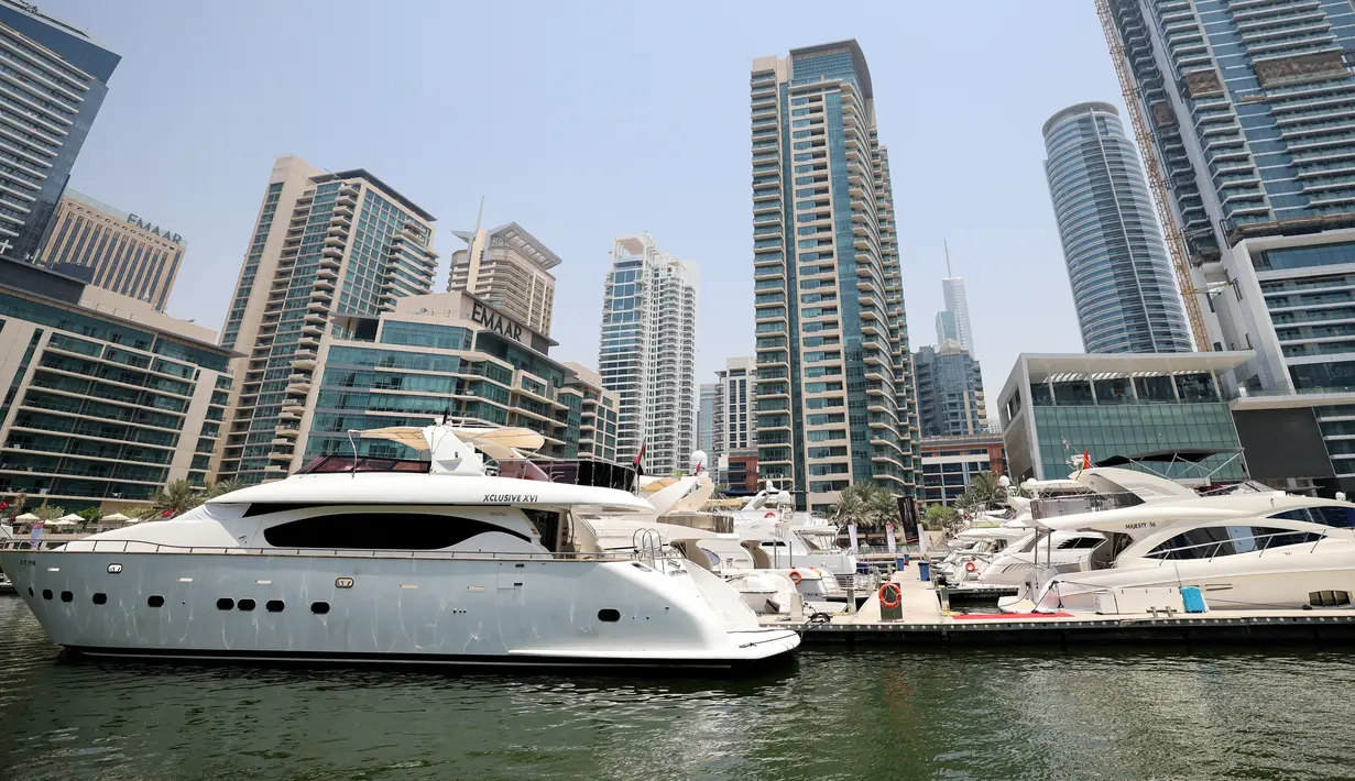Kapal pesiar mewah bersandar di Dubai Marina Beach di emirat Teluk, pada 10 Juni 2021. Di tengah aturan pandemi di mana warga harus menjaga jarak dan menghindari keramaian, orang-orang kaya di Dubai memiliki cara mereka bisa pergi berekreasi, yaitu jalan-jalan dengan kapal pesiar. (Karim SAHIB/AFP)