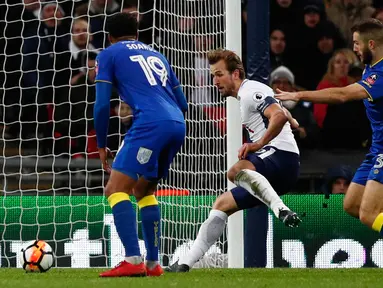 Striker Tottenham Hotspur, Harry Kane berhasil mencetak gol ke gawang Wimbledon pada pertandingan putaran ketiga FA Cup di Stadion Wembley, Minggu (7/1). Tottenham Hotspur lolos ke babak keempat Piala FA usai menang telak 3-0. (Adrian DENNIS/AFP)