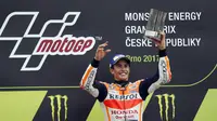 Marc Marquez mengangkat trofi juara usai mengalahkan para pebalap lainya pada balapan MotoGP Republik Ceska di Sirkuit Brno, (6/8/2017). (AP/Petr David Josek)