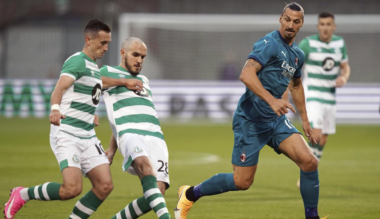 Penyerang AC Milan, Zlatan Ibrahimovic, berebut bola dengan bek Shamrock Rovers, Joey O'Brien, pada laga babak kualifikasi Luga Europa 2020/2021 di Tallaght Stadium, Jumat (18/9/2020) dini hari WIB. AC Milan menang 2-0 atas Shamrock Rovers. (Spada/LaPresse via AP)