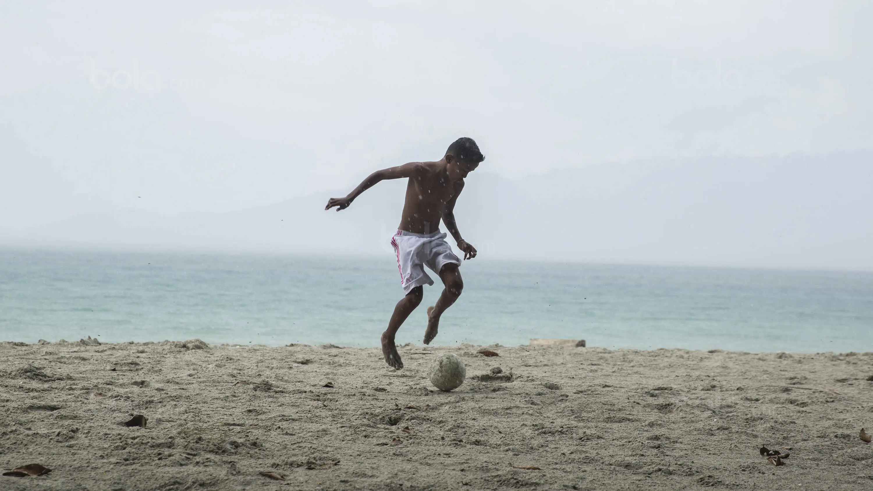 Pesepak bola SSB Tulehu Putra, Saleh Al'Ayubi Pary berlatih di tepi Pantai Tial. (Bola.com/Vitalis Yogi Trisna)