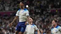 Pemain Inggris, Marcus Rashford (kiri) merayakan gol pertama timnya ke gawang Wales yang dicetak lewat tendangan bebas saat matchday ketiga Grup B Piala Dunia 2022 di Ahmad Bin Ali Stadium, Rabu (30/11/2022). (AP/Frank Augstein)