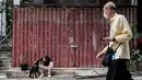 Etienne Simonnet duduk bersama anjing angkatnya Ah Po, yang ditangani Hong Kong Dog Rescue (HKDR) dan kelompok lain di Hong Kong, 14 April 2020. Sejak pandemi corona Covid-19, kelompok kesejahteraan hewan HKDR berusaha berjuang lantaran semua acara penggalangan dana dibatalkan. (Anthony WALLACE/AFP)