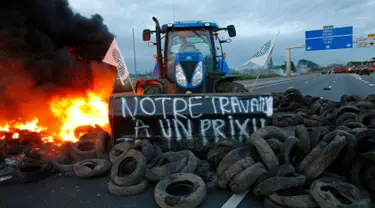 Para petani Perancis memblokir salah satu ruas jalan utama di Seclin, Perancis, Rabu (22/7/2015). Petani Perancis memprotes karena belum mendapatkan keuntungan dari kenaikan harga daging dan susu yang dijual di pasaran. (REUTERS/Pascal Rossignol)