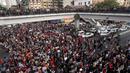 Para pengunjuk rasa berjalan di persimpangan jalan besar saat demonstrasi menentang kudeta militer di Yangon, Myanmar pada Sabtu (6/2/2021). Sebagian besar mengangkat tangan sambil menunjukkan simbol tiga jari yang melambangkan perlawanan terhadap pengambilalihan oleh militer. (STR / AFP)