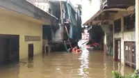 Seorang Warga Berenang Untuk Membagikan Makanan Bagi Korban Banjir di Kebon Pala, Jakarta Timur, Rabu (1/1/2020). (Foto: Nanda Perdana Putra/Liputan6.com)
