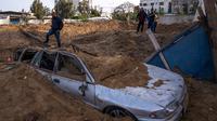 Foto-foto memperlihatkan lubang-lubang besar seperti kawah di Kota Gaza bekas serangan rudal dari Israel. (AP Photo/Fatima Shbair)
