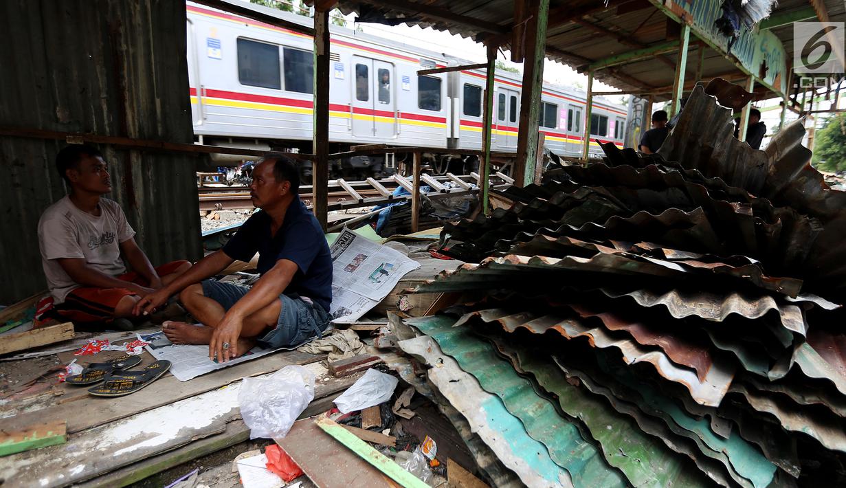 Warga berbincang didekat bongkaran rumah di area Rusun Bendungan Hilir (Benhil) II, Jakarta, Minggu (3/12). Bangunan liar tersebut dibongkar karena berdiri di atas lahan PT Kereta Api Indonesia (PT KAI). (Liputan6.com/JohanTallo)