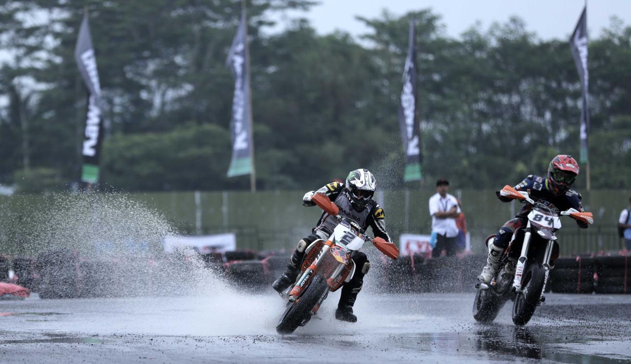 Richard Dibben (kanan), pebalap asal Selandia Baru mencoba menyalip Eric Chia (kiri) pebalap asal Singapura  pada ajang FIM Asia Supermoto 2016 di Kompleks Stadion Kanjuruhan, Malang, Sabtu (8/10/2016) (Bola.com/Reza Bachtiar)