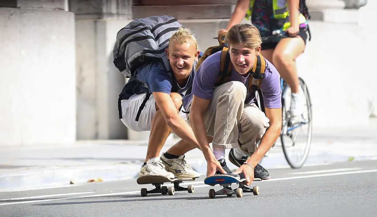Orang-orang bermain papan luncur di sebuah jalan dalam acara Hari Minggu Bebas Kendaraan Bermotor (Car Free Sunday) di Brussel, Belgia, pada 20 September 2020. (Xinhua/Zheng Huansong)