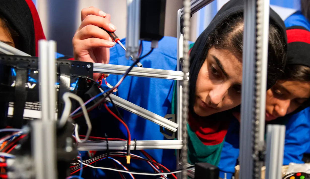 Ekspresi salah satu anggota, Liza Azizi saat memperbaiki masalah pada robot sebelum pembukaan The First Global Challenge di Washington, AS, Minggu (16/7). Bagi mereka, tahun ini adalah kompetisi tahunan robotik untuk pertama kalinya. (AP/Cliff Owen)